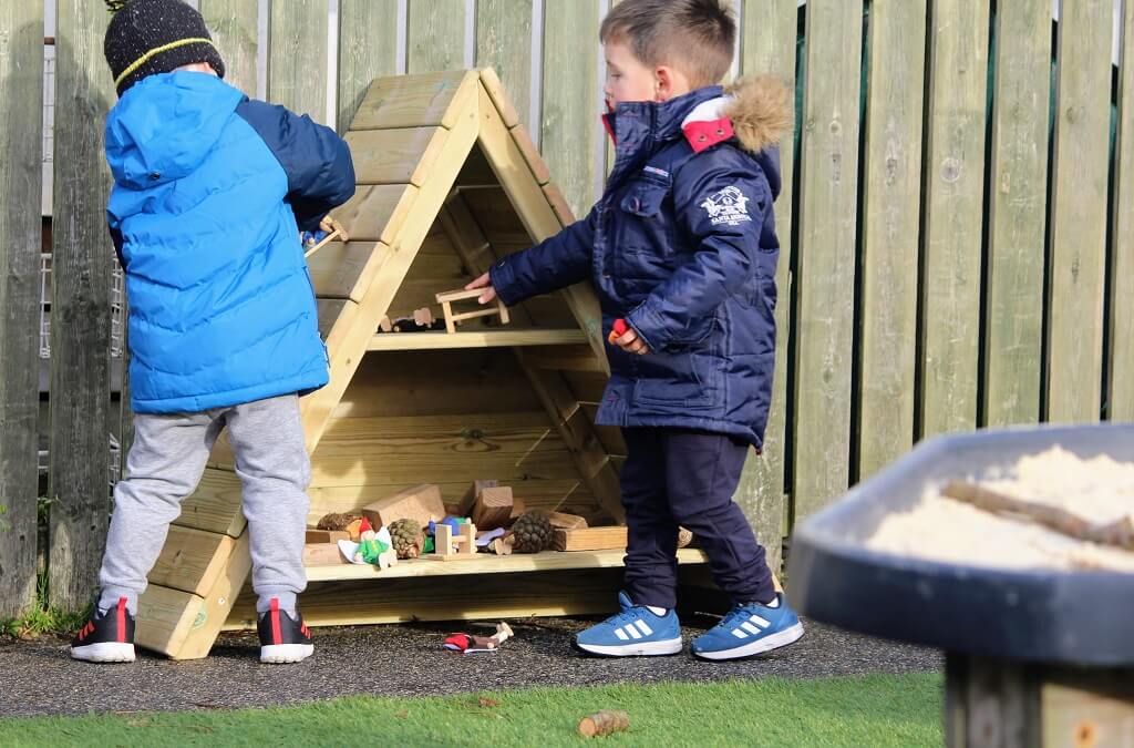 Children exploring outdoor nursery play area