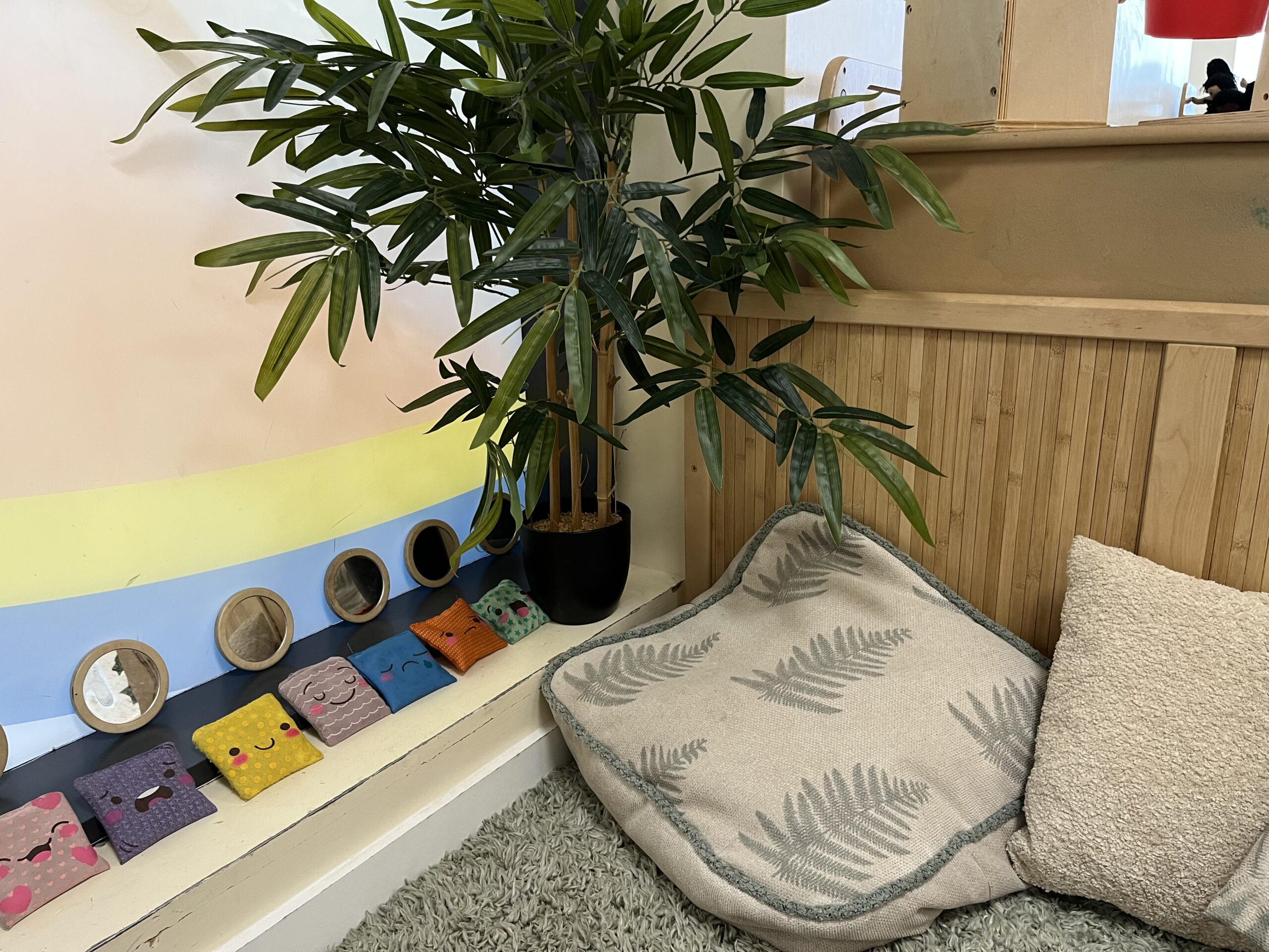 a quiet cosy corner with an artificial tree, cushions and bean bags
