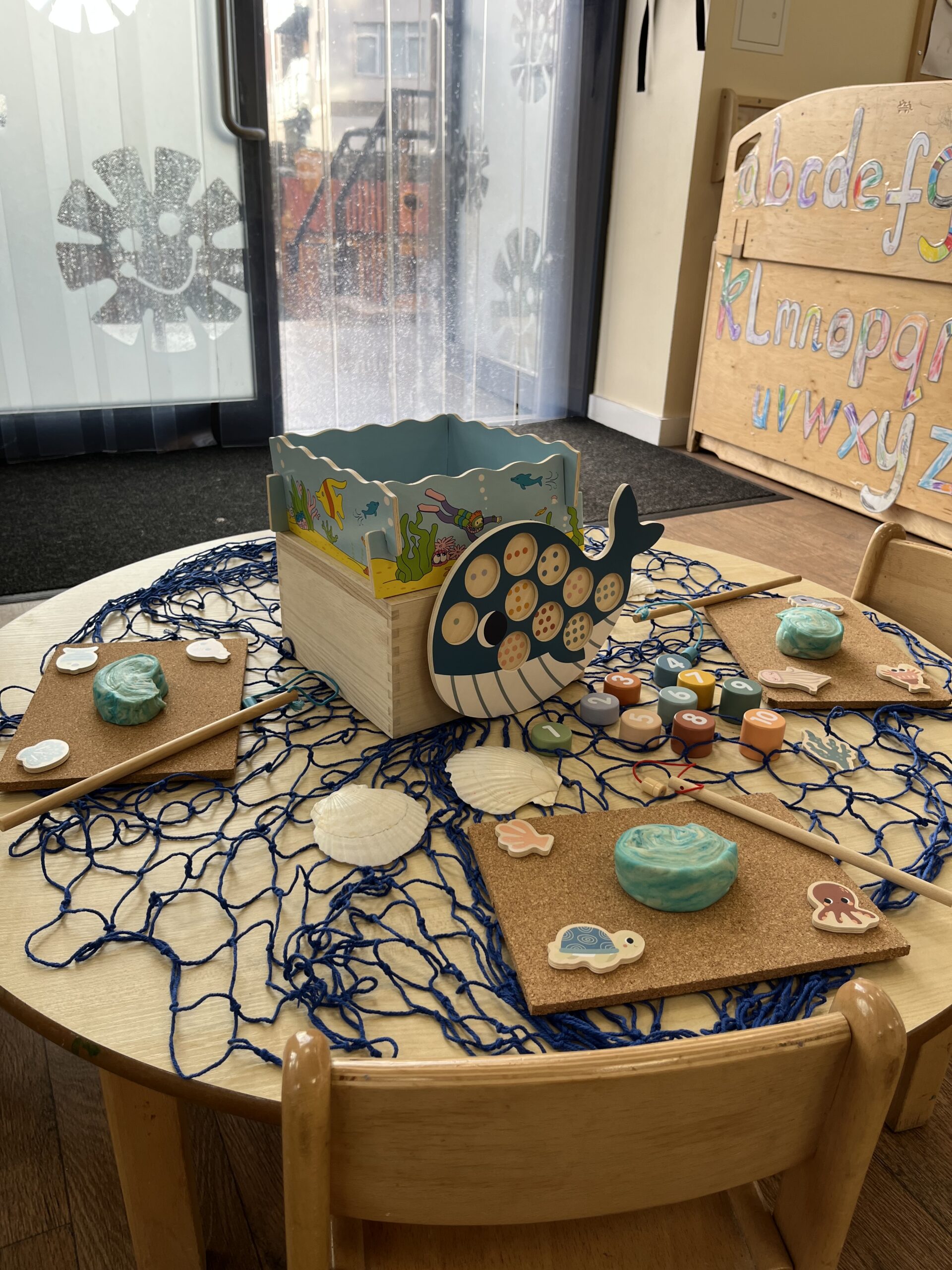 a sea themed table with blue playdoe and a book about a whale