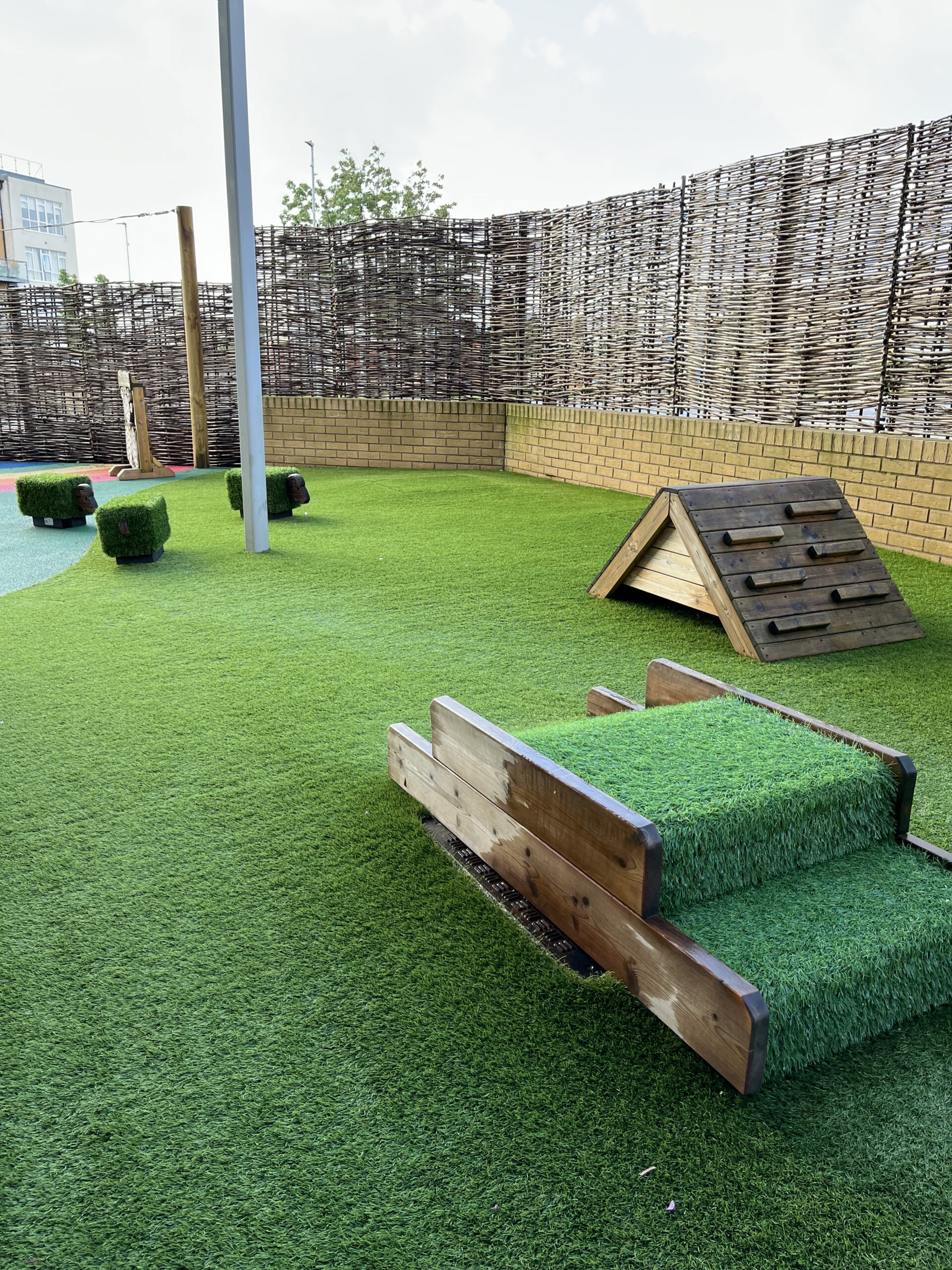 the garden area at charlton heights outside the baby room with crawling frames and other apparatus for them to explore
