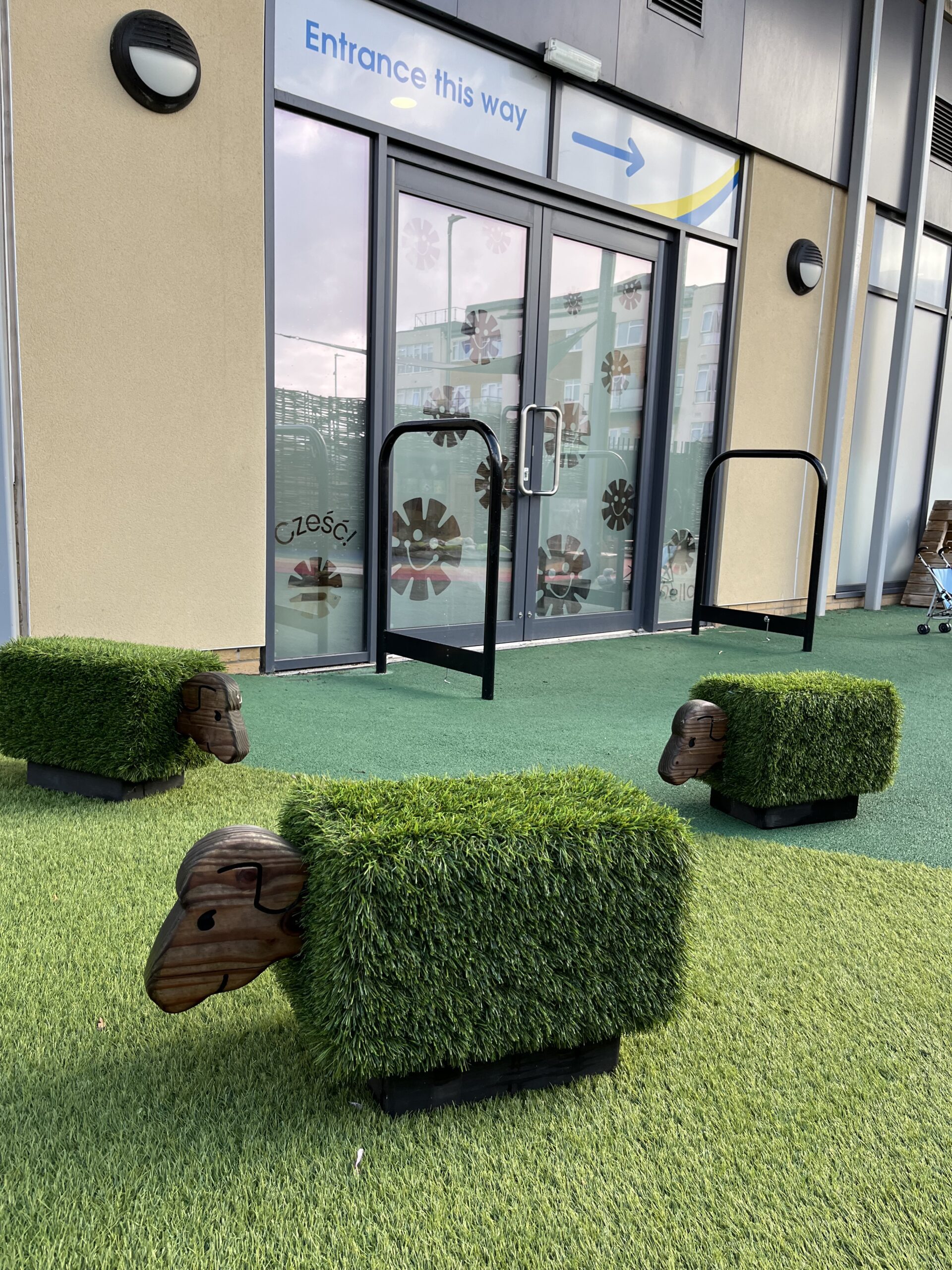 the garden area at charlton heights outside the baby room with 3 faux grass sheeps for them to climb on