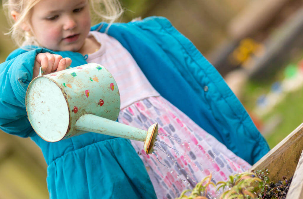 Child playing with outdoor watering can
