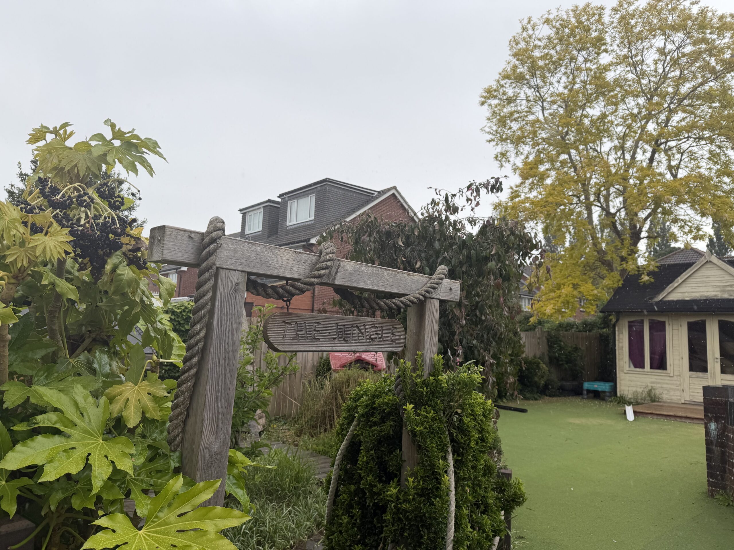 jungle play area in garden with lots of plants and hides for children