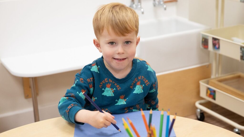 Boy coloring as part of a positive transition to school, building fine motor skills and creativity.